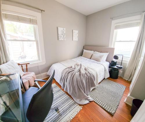 a bedroom with a bed and two windows at Luxe 3BR Apartment at MIT Harvard with FREE parking in Cambridge