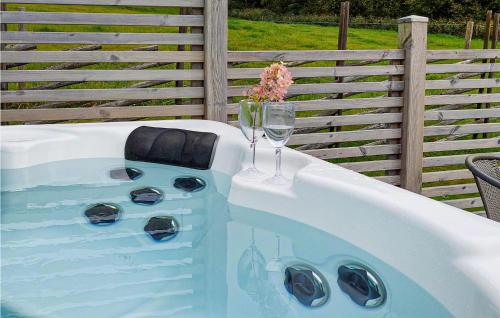 a hot tub with a glass of wine and a glass of wine at 5 Bedroom Amazing Home In Bjrketorp in Björketorp