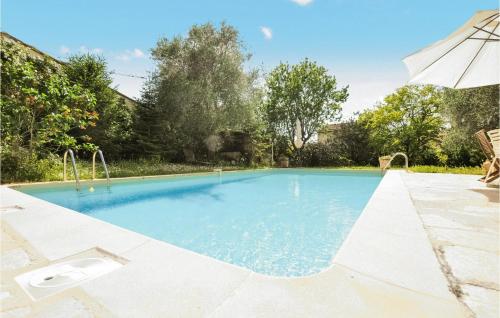 a swimming pool in a yard with an umbrella at Gorgeous Home In Mouans-sartoux With Heated Swimming Pool in Mouans-Sartoux