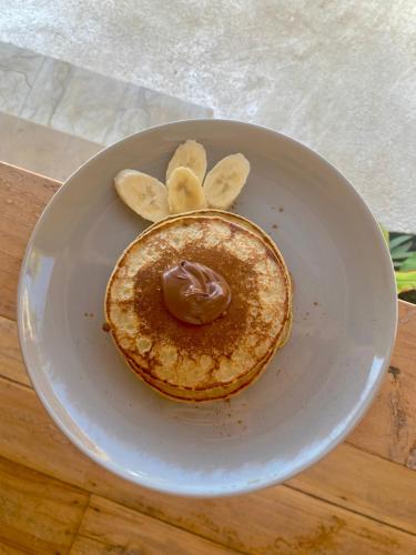 a plate of pancakes with chocolate and banana slices at My Island Home Gili Air in Gili Air