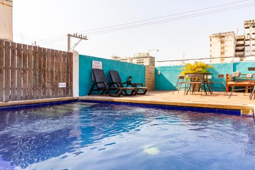 a swimming pool with chairs and a table on a balcony at Gagaka Rua hostel in Santa Marta