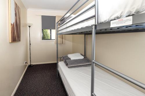 a bedroom with two bunk beds in a room at BIG4 Hobart Airport Tourist Park in Cambridge
