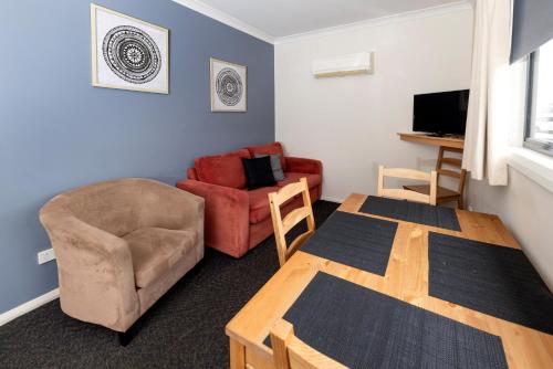 a living room with a table and a chair at BIG4 Hobart Airport Tourist Park in Cambridge