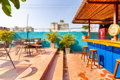 a patio with a bar and tables and chairs at Gagaka Rua hostel in Santa Marta