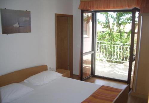 a bedroom with a bed and a sliding glass door at Josip II - 150 m from beach in Baška Voda