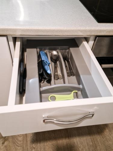 a drawer in a kitchen counter with utensils at Apartament Alina - la parter & parcare rezervata in Deva