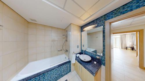 y baño con bañera y lavamanos. en Al Dabas Beach Views, 3BD Sleeps 6, Beachfront Beach & Pool Access en Dubái