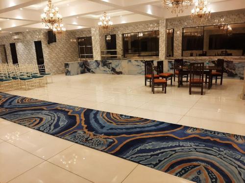 a dining room with a table and chairs and a rug at Hotel Mandi Heights - Bar, Fine Dining & Banquet Hall in Mandi