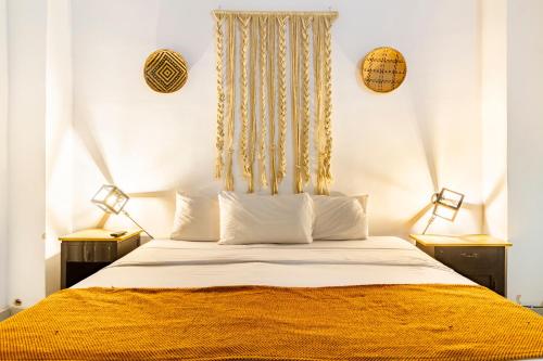 a bedroom with a large bed with two lamps at Gagaka Rua hostel in Santa Marta