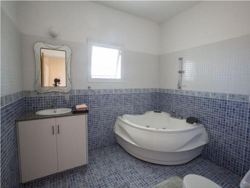 uma casa de banho com uma banheira grande e um lavatório em Carilisto Villas Big 4 Bedrooms in Center of Ayia Napa em Agia Napa