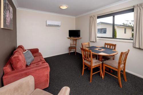 a living room with a couch and a table and chairs at BIG4 Hobart Airport Tourist Park in Cambridge