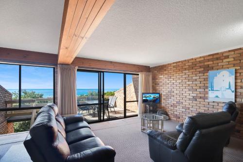 a living room with a couch and chairs and a television at Carlaminda Peregian Beach in Peregian Beach