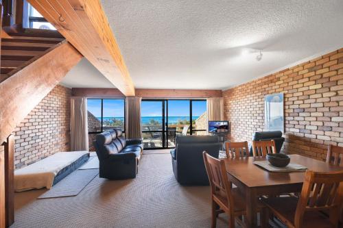 a living room with a couch and a table at Carlaminda Peregian Beach in Peregian Beach