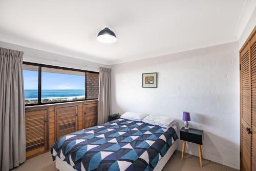 a bedroom with a bed and a large window at Carlaminda Peregian Beach in Peregian Beach