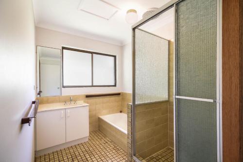 a bathroom with a tub and a sink and a shower at Carlaminda Peregian Beach in Peregian Beach