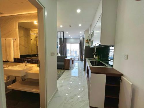 ein großes Bad mit einem Waschbecken und einem großen Spiegel in der Unterkunft Asahi Luxstay - D'el Dorado Apartment in Hanoi