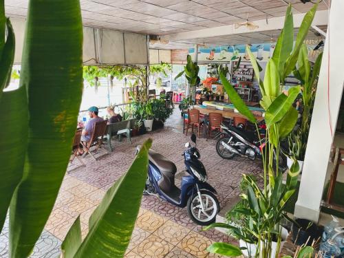 uma scooter estacionada dentro de um restaurante com plantas em N'T Homestay em Mui Ne