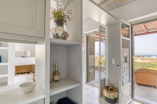 a bathroom with white walls and a sink and a window at Villa Vino - Cycladic Calm in Isterni
