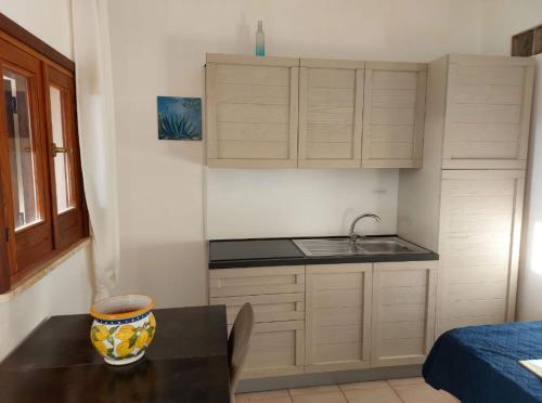 a small kitchen with a table and a sink at Aura - Le due Lune in Lampedusa