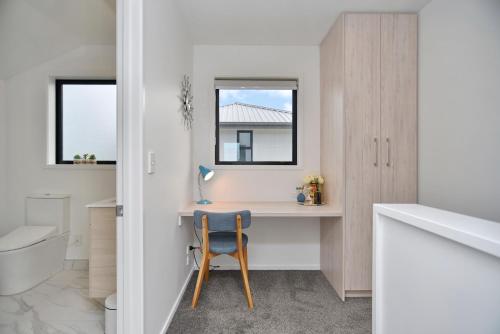 a bathroom with a desk and a chair in a room at Sea air and Sandy Beach, beautiful 1 bed 1 bath in Christchurch