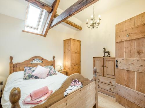 a bedroom with a wooden bed and a wooden cabinet at The Stables in Bream