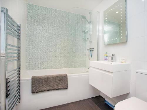 a white bathroom with a tub and a sink at Malborough Park in Malborough