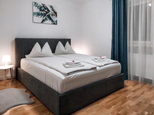 a bedroom with a large bed with a black headboard at Apartament Alina - la parter & parcare rezervata in Deva