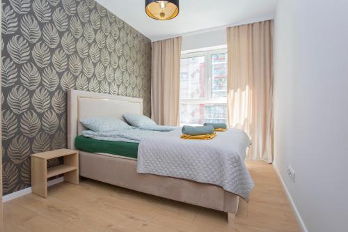 a bedroom with a bed and a window at Urban Jungle apartament Emily in Białystok