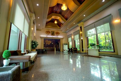 a lobby with couches and tables in a building at Pearl Resort & Hotel in Nonthaburi