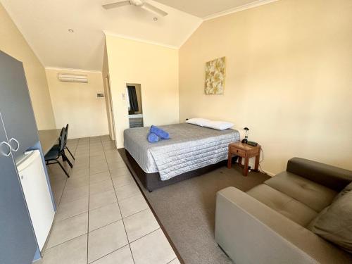 ein Hotelzimmer mit einem Bett und einem Sofa in der Unterkunft Moura Motel in Moura