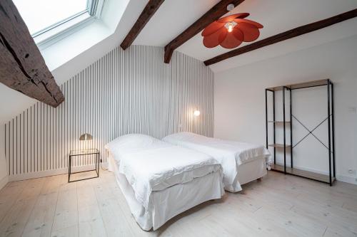 deux lits dans une chambre aux murs blancs dans l'établissement Les Mansardes : Duplex champenois typique et cosy, à Ay