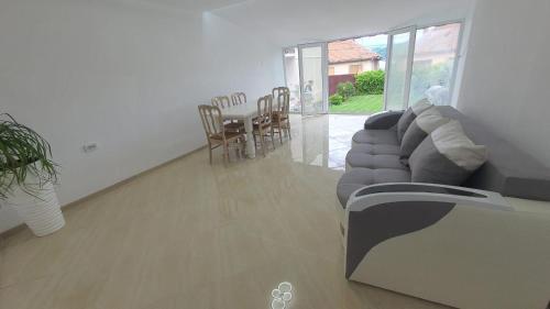 a living room with a couch and a table and chairs at Sîrbu Orsova in Orşova