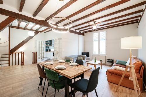 un salon avec une table et un canapé dans l'établissement Les Mansardes : Duplex champenois typique et cosy, à Ay