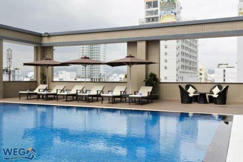 a pool with chairs and umbrellas on a building at Căn hộ nghỉ dưỡng bên bờ biển in Dong Quan