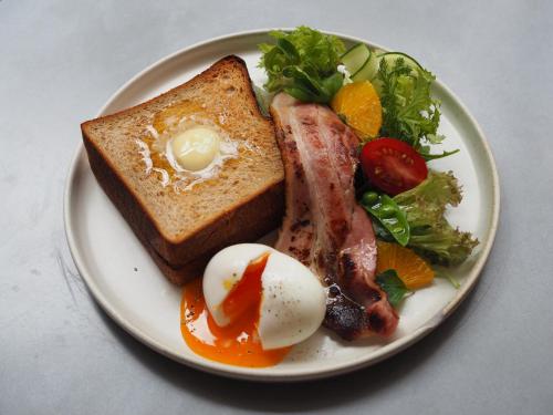 een bord ontbijtproducten met eieren, spek en toast bij ASA Village in Shirahama