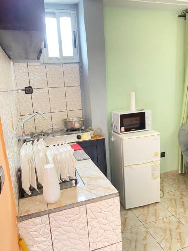 a kitchen with a counter top with a white refrigerator at N-E Studio meublé 2 in Douala