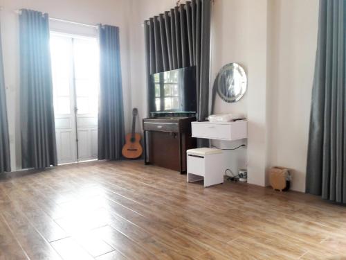a living room with a wooden floor and a television at Hồng Dương Villa Homestay - phòng đôi view sông Hương trung tâm thành phố #101 in Hue