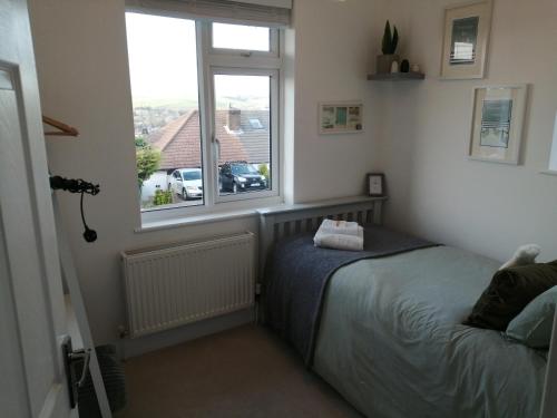 a bedroom with a bed and a window at South Downs View in Brighton & Hove