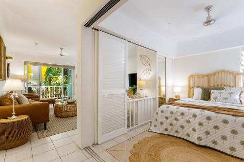 um quarto com uma cama e uma sala de estar em Oasis Luxe on Macrossan Street - Stylish Residence em Port Douglas