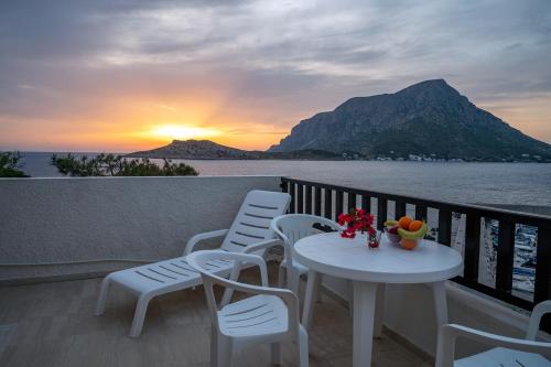 a table and chairs on a balcony with a view of the ocean at Pelagos Seafront Accommodation - Maria in Myrties