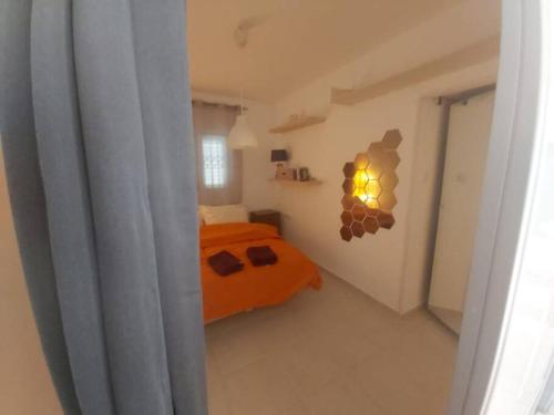 a bedroom with an orange bed and a window at near the sea even 14 days won't feel enough in Bat Yam