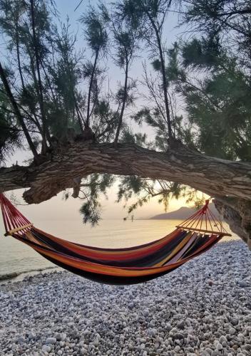 a hammock hanging from a tree on a beach at Blue Coast House in Goúdhouros