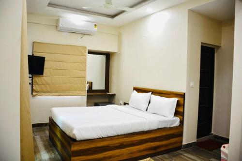 - une chambre avec un lit doté de draps et d'oreillers blancs dans l'établissement Hotel Royal Residency, à Kolkata