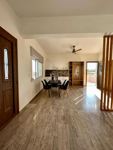 a dining room and living room with a table and chairs at Nautica Hotel Apartments in Stavromenos