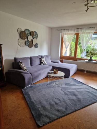 - un salon avec un canapé violet et un tapis bleu dans l'établissement Ferienwohnung Milan, à Oberstaufen
