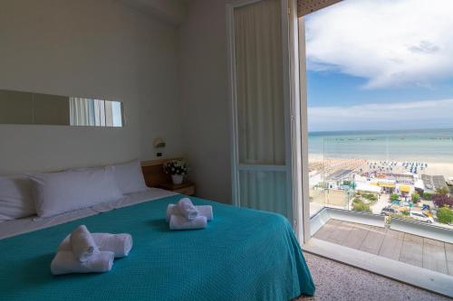 - une chambre avec un lit et une grande fenêtre dans l'établissement Hotel Atlas, à Cesenatico