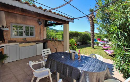 un patio avec une table et des chaises et une cuisine dans l'établissement Lovely Home In Lussas, à Lussas