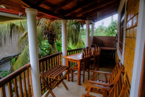 a porch with a table and chairs on it at purple villa in Mirissa