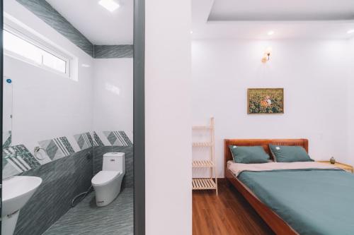 two views of a bedroom with a bed and a bathroom at 3 Tầng Mây (Homestay & Coffee) in Ấp Ða Lôc