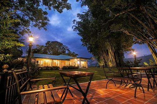 a patio with two benches and a table and a lamp at Mandira Strathdon by HPL in Watawala